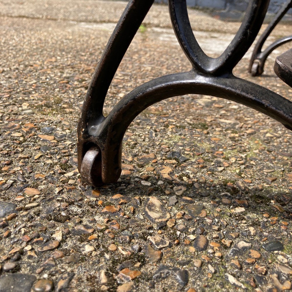 An oak-cased Singer sewing machine side table with side drawers mounted on a black cast iron treadle base. View IX