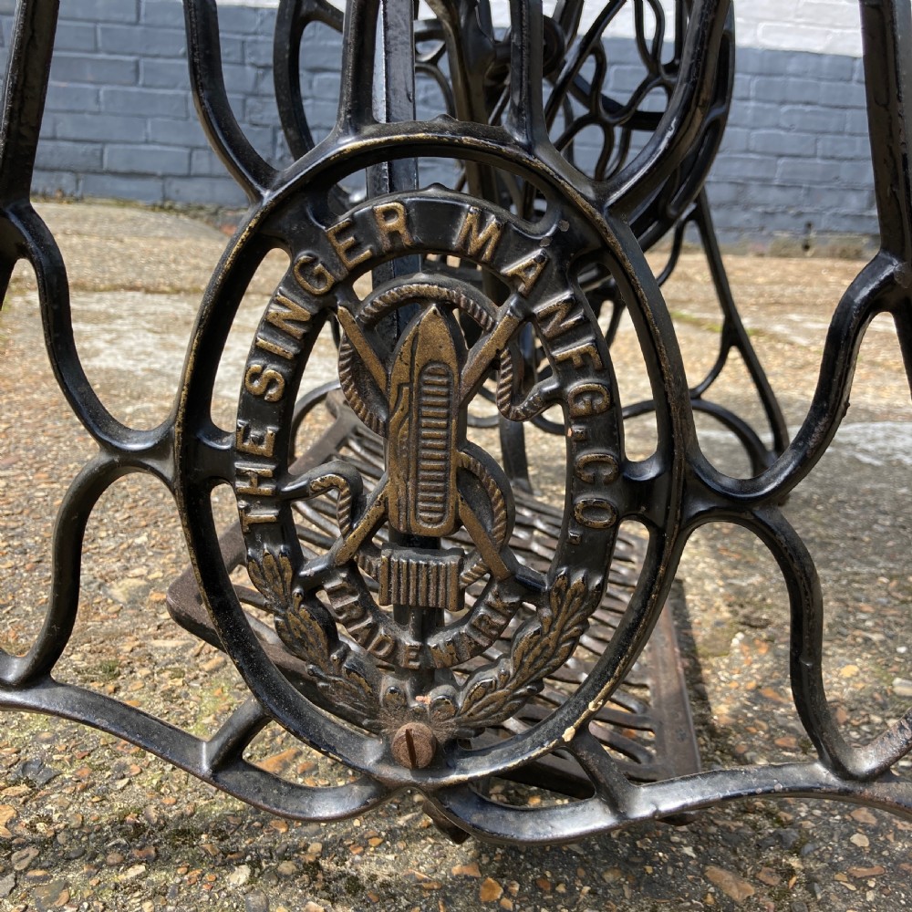 An oak-cased Singer sewing machine side table with side drawers mounted on a black cast iron treadle base. View X