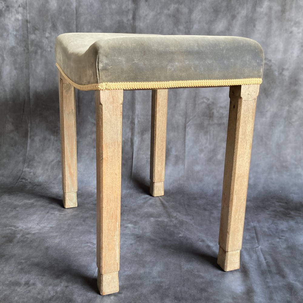 A 1937 King George VI coronation stool featuring a limed oak frame, chamfered legs, and a concave velvet seat edged with gold braid. View IX