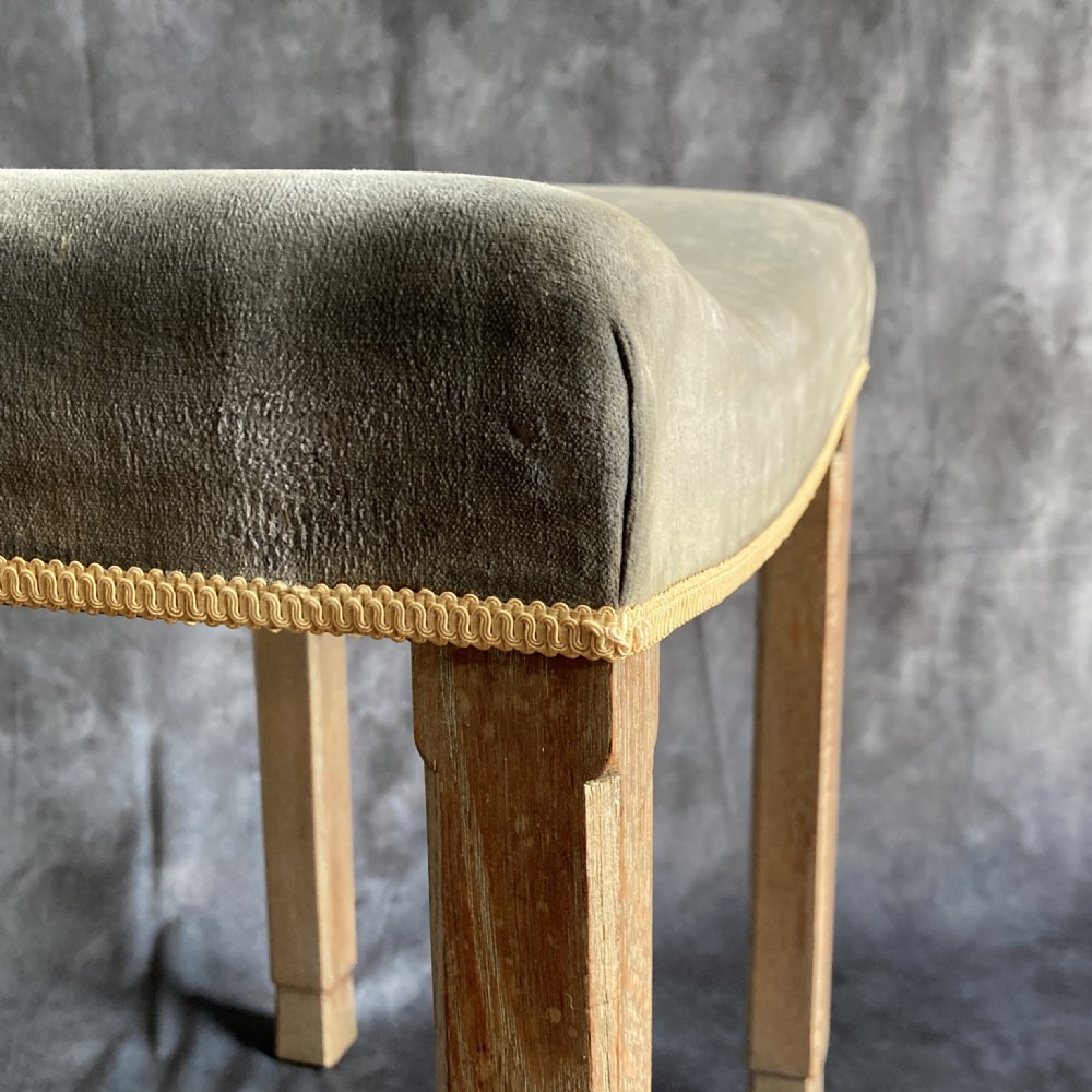 A 1937 King George VI coronation stool featuring a limed oak frame, chamfered legs, and a concave velvet seat edged with gold braid. View X