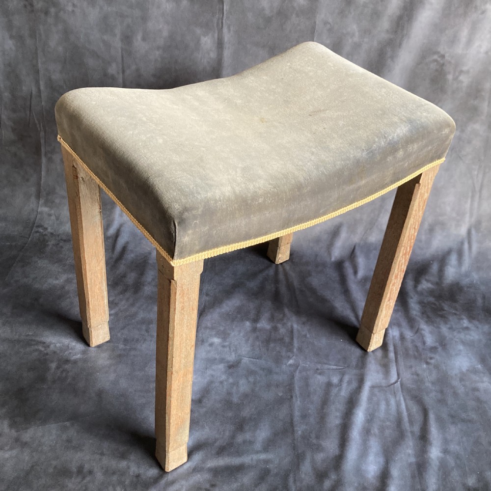 A 1937 King George VI coronation stool featuring a limed oak frame, chamfered legs, and a concave velvet seat edged with gold braid. View XVIII