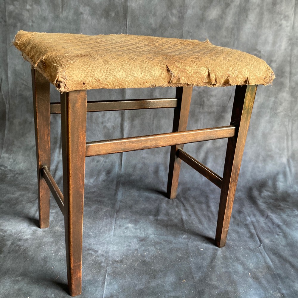 A pair of early 20th-century dark oak stools featuring patterned gold upholstery and rectangular tapered legs. View V
