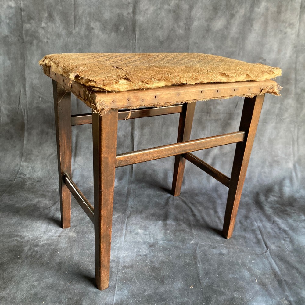 A pair of early 20th-century dark oak stools featuring patterned gold upholstery and rectangular tapered legs. View VI