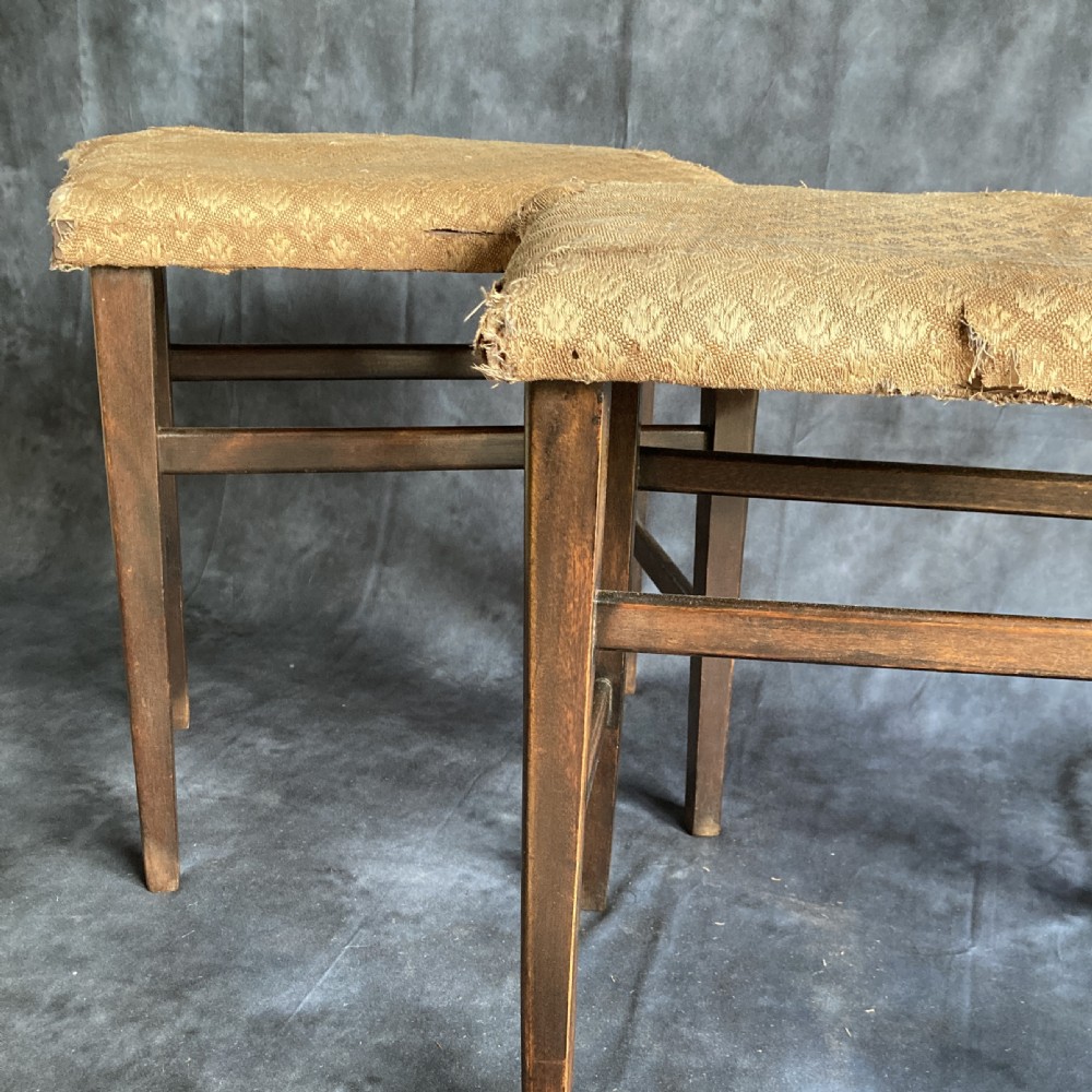 A pair of early 20th-century dark oak stools featuring patterned gold upholstery and rectangular tapered legs. View VII