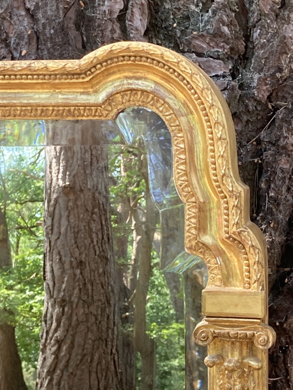 A tall late 18th-century giltwood pier glass mirror featuring fluted pilasters, classical capitals, and a shaped bevelled glass plate. View VI