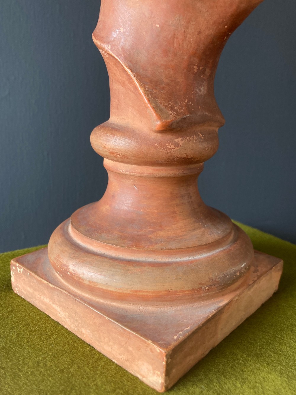 An Italian terracotta male portrait bust with swept hair and a distressed surface, set on a circular socle and square base. View VIII