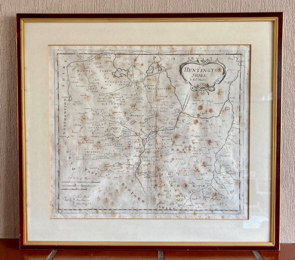 An 18th-century engraved map of Huntington Shire by Robert Morden, set within a cream mount and a dark wood frame with a gilt inner slip.