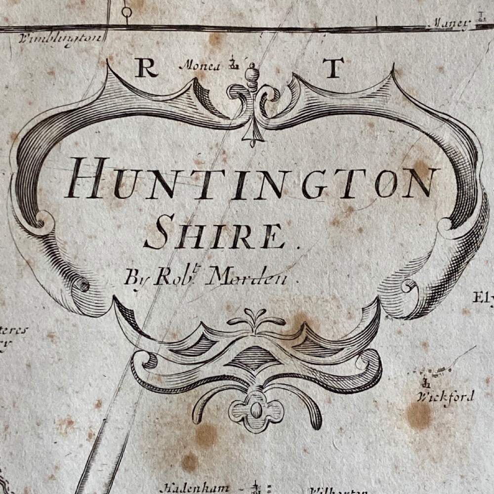 An 18th-century engraved map of Huntington Shire by Robert Morden, set within a cream mount and a dark wood frame with a gilt inner slip. View II