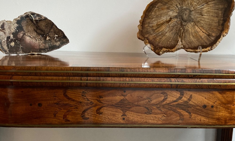 A late Georgian mahogany fold-over tea table featuring an inlaid apron and four reeded legs. View VI