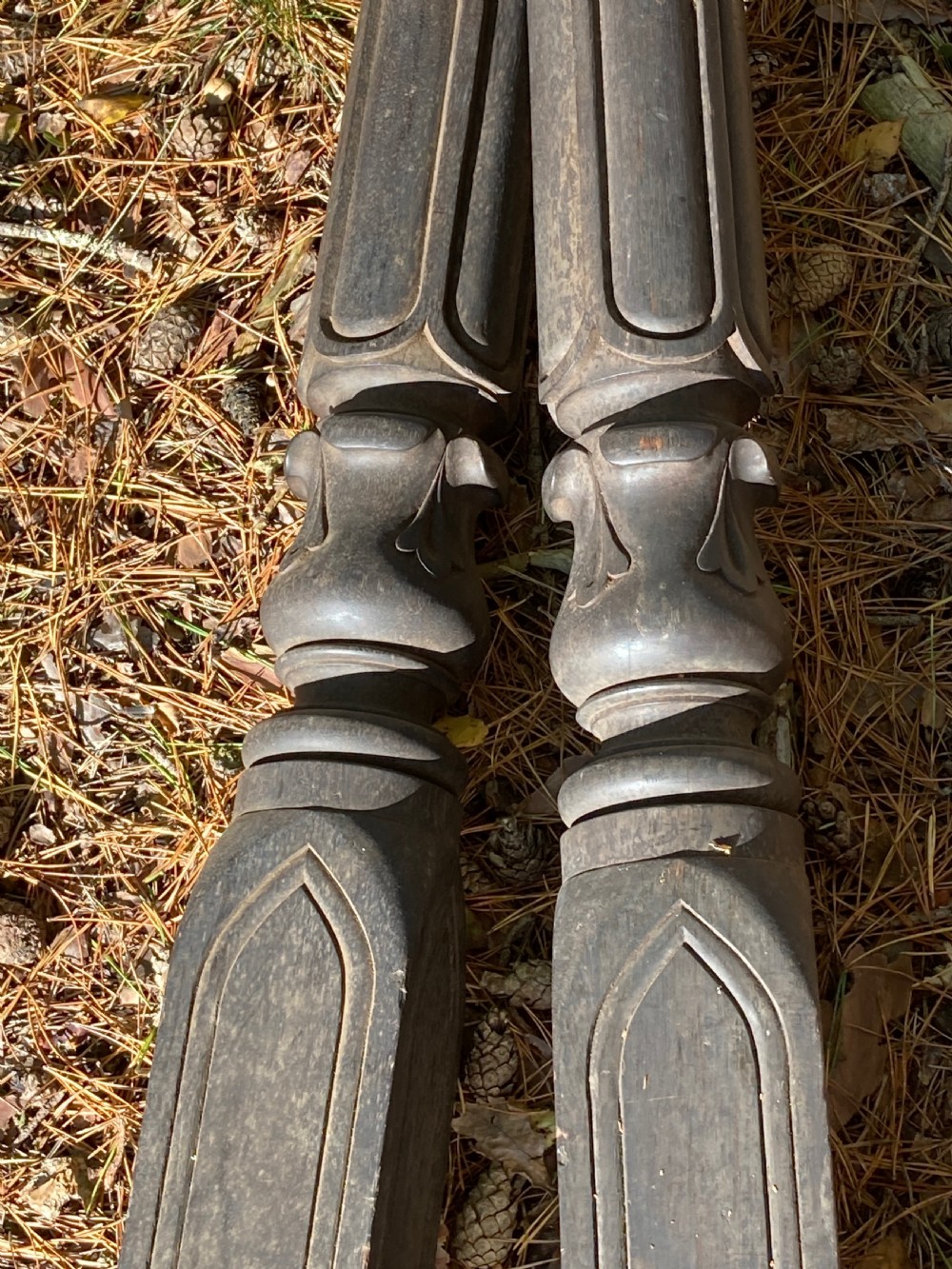 A pair of 19th-century dark carved wooden bedposts featuring fluted upper shafts and panelled lower bases. View VII