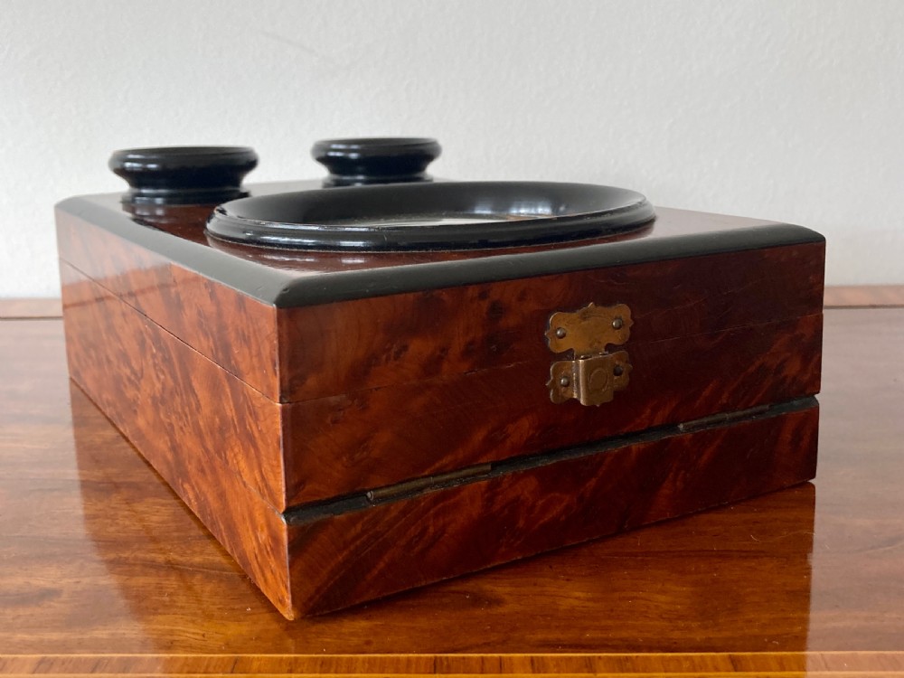 An antique Victorian hinged burr yew wood tabletop stereoscope shown open, featuring dual circular viewing lenses, a central magnifying lens, and a selection of stereoview cards. View III