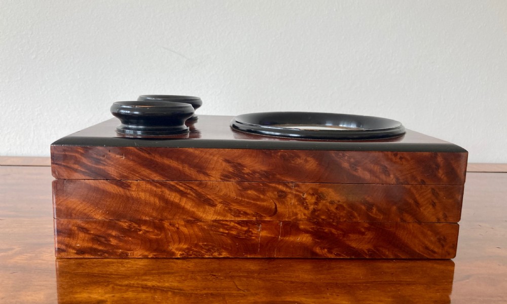 An antique Victorian hinged burr yew wood tabletop stereoscope shown open, featuring dual circular viewing lenses, a central magnifying lens, and a selection of stereoview cards. View VIII