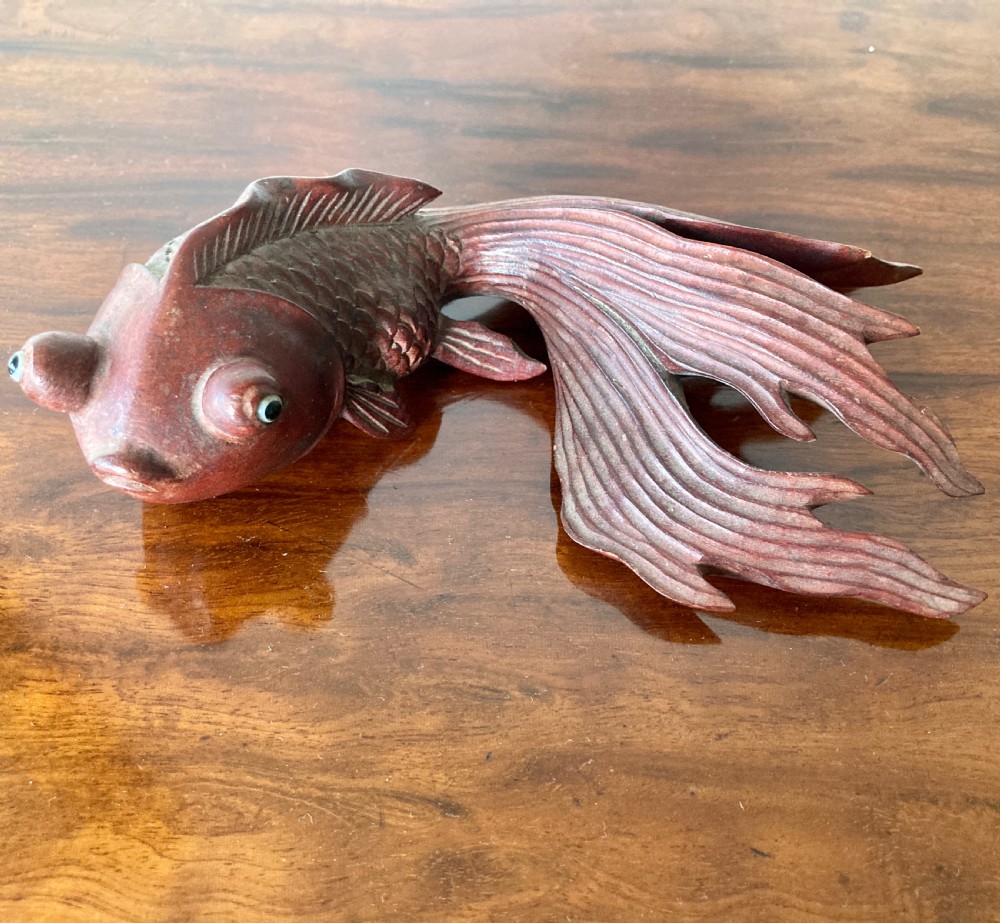 Three 19th-century Oriental carved wooden goldfish figures with detailed scales, flowing fins, and inset glass eyes displayed on a polished surface. View II