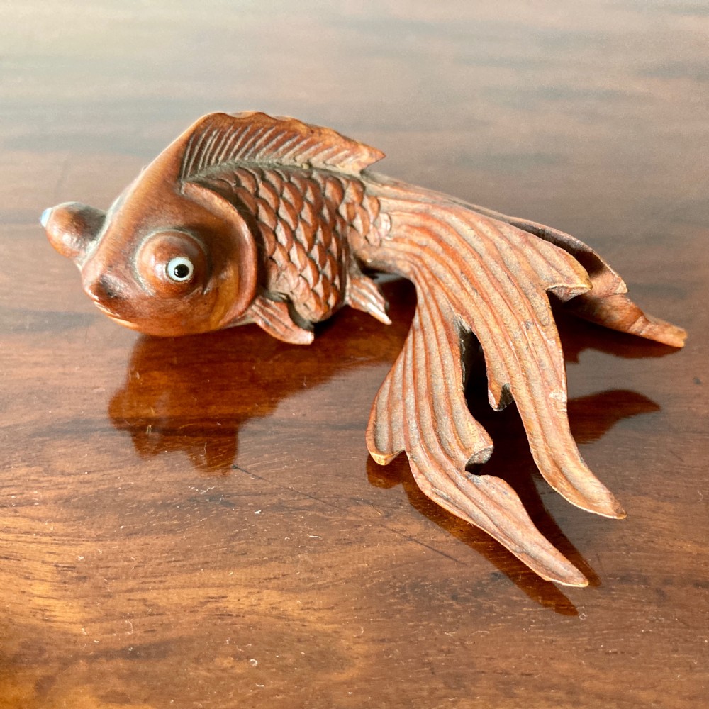 Three 19th-century Oriental carved wooden goldfish figures with detailed scales, flowing fins, and inset glass eyes displayed on a polished surface. View IV