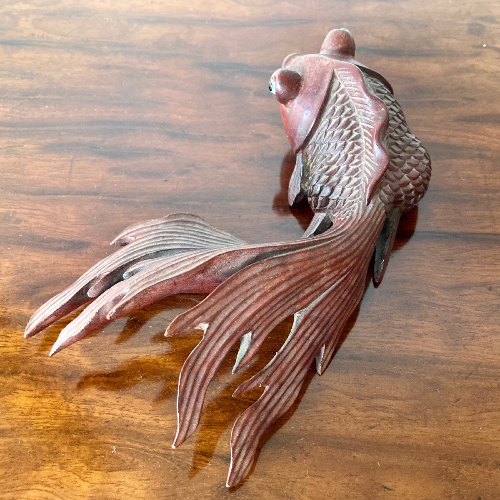 Three 19th-century Oriental carved wooden goldfish figures with detailed scales, flowing fins, and inset glass eyes displayed on a polished surface. View VII