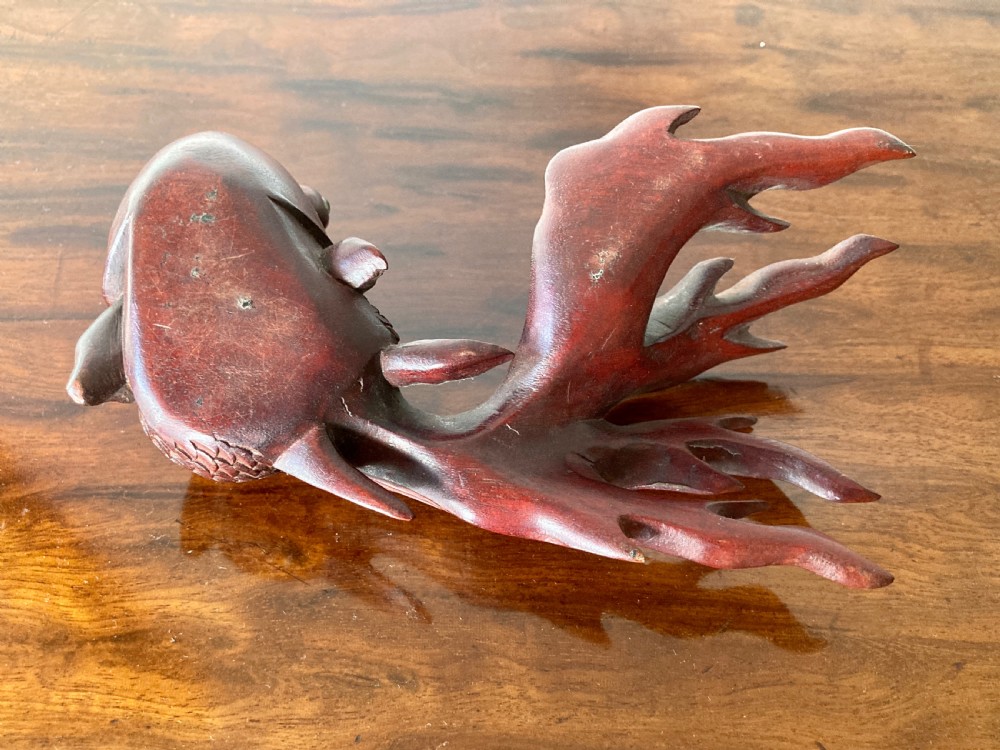 Three 19th-century Oriental carved wooden goldfish figures with detailed scales, flowing fins, and inset glass eyes displayed on a polished surface. View VIII