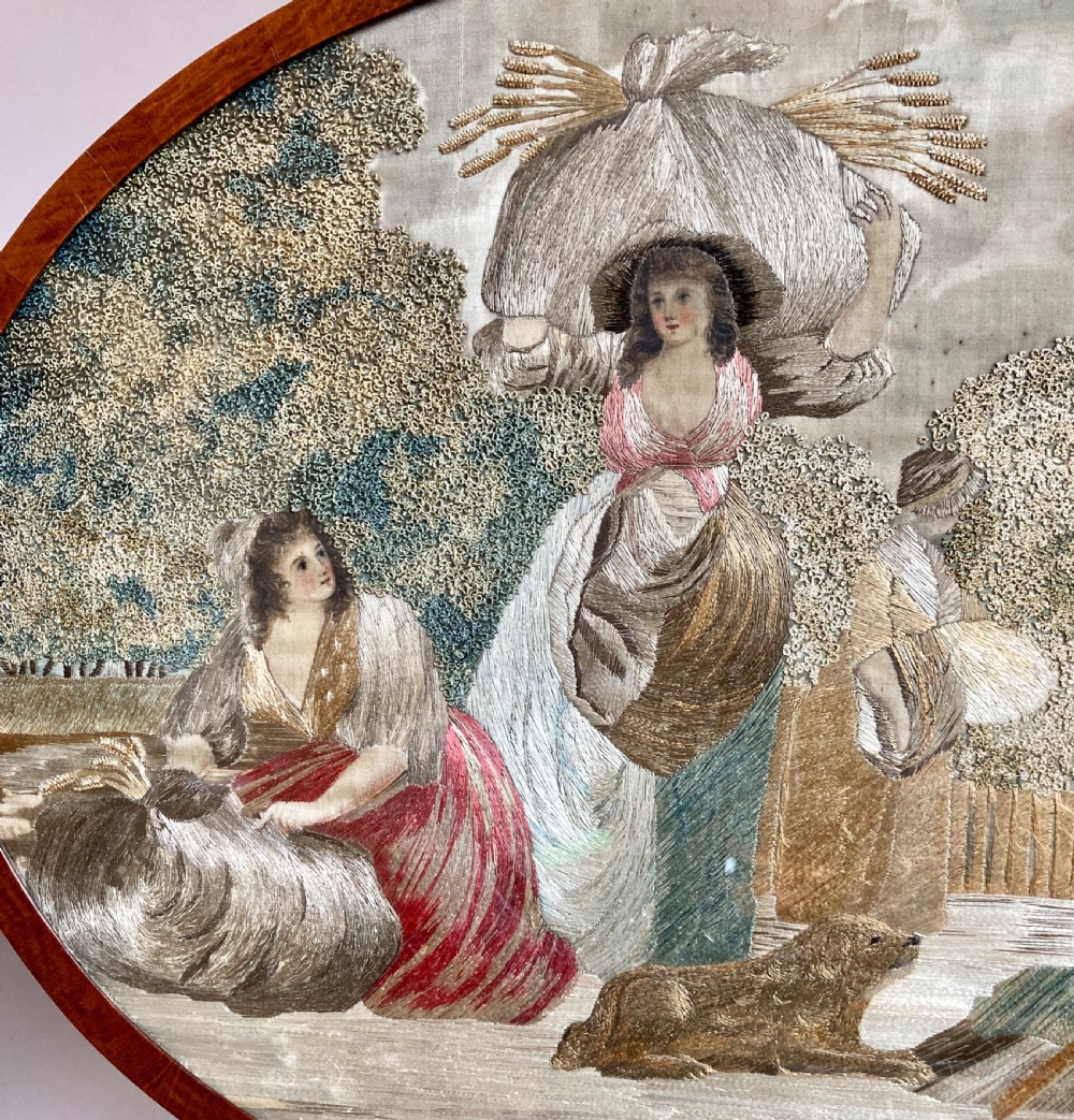 An oval mahogany fire screen containing an 18th-century silk needlework scene of pastoral figures, mounted on a central wooden pole. View III