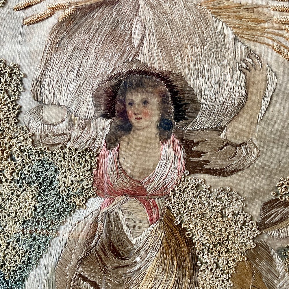 An oval mahogany fire screen containing an 18th-century silk needlework scene of pastoral figures, mounted on a central wooden pole. View VI