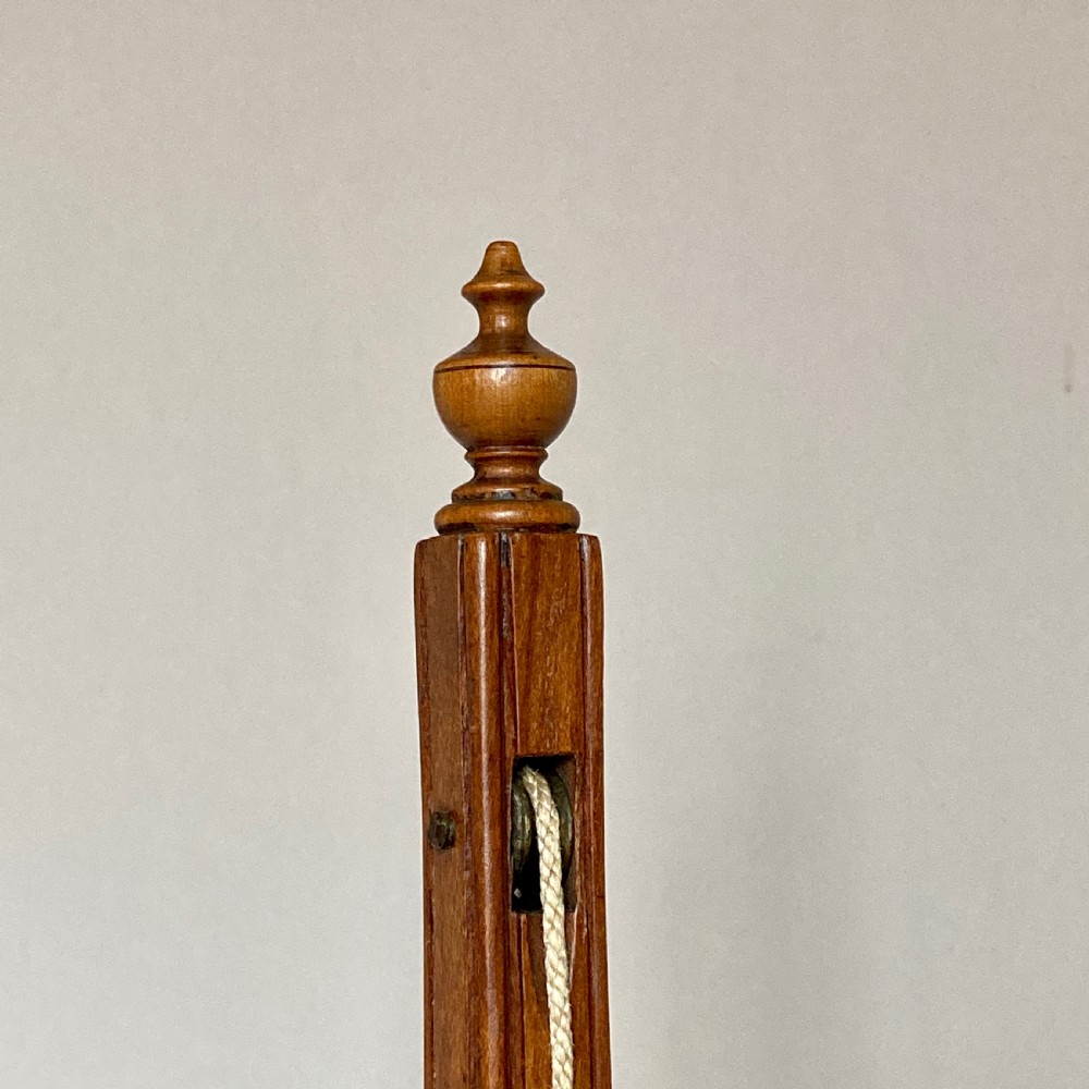 An oval mahogany fire screen containing an 18th-century silk needlework scene of pastoral figures, mounted on a central wooden pole. View VIII