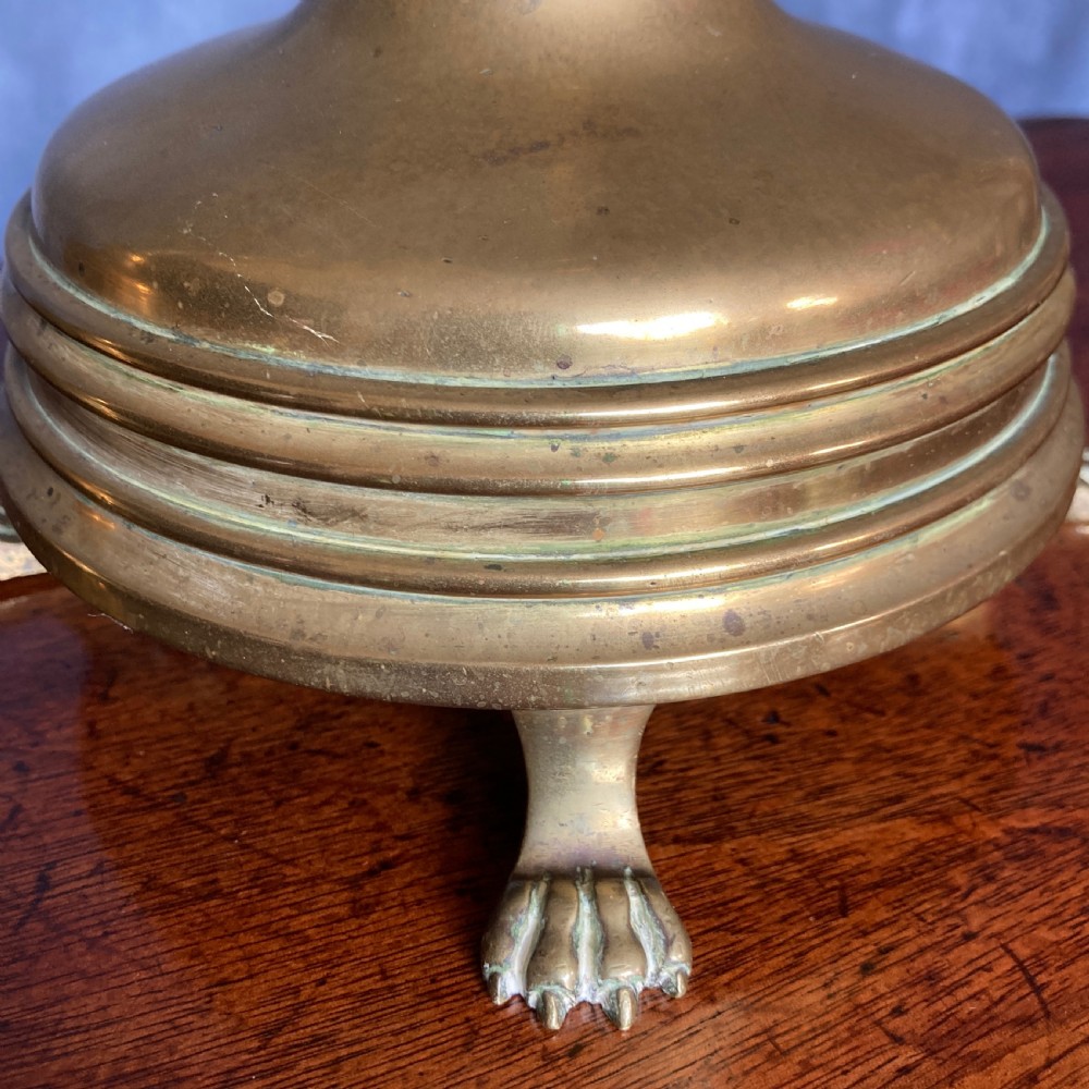 A pair of tall Victorian Gothic Revival cast brass candlesticks featuring pierced crenellated drip pans, knopped stems, and stylized paw feet. View IX
