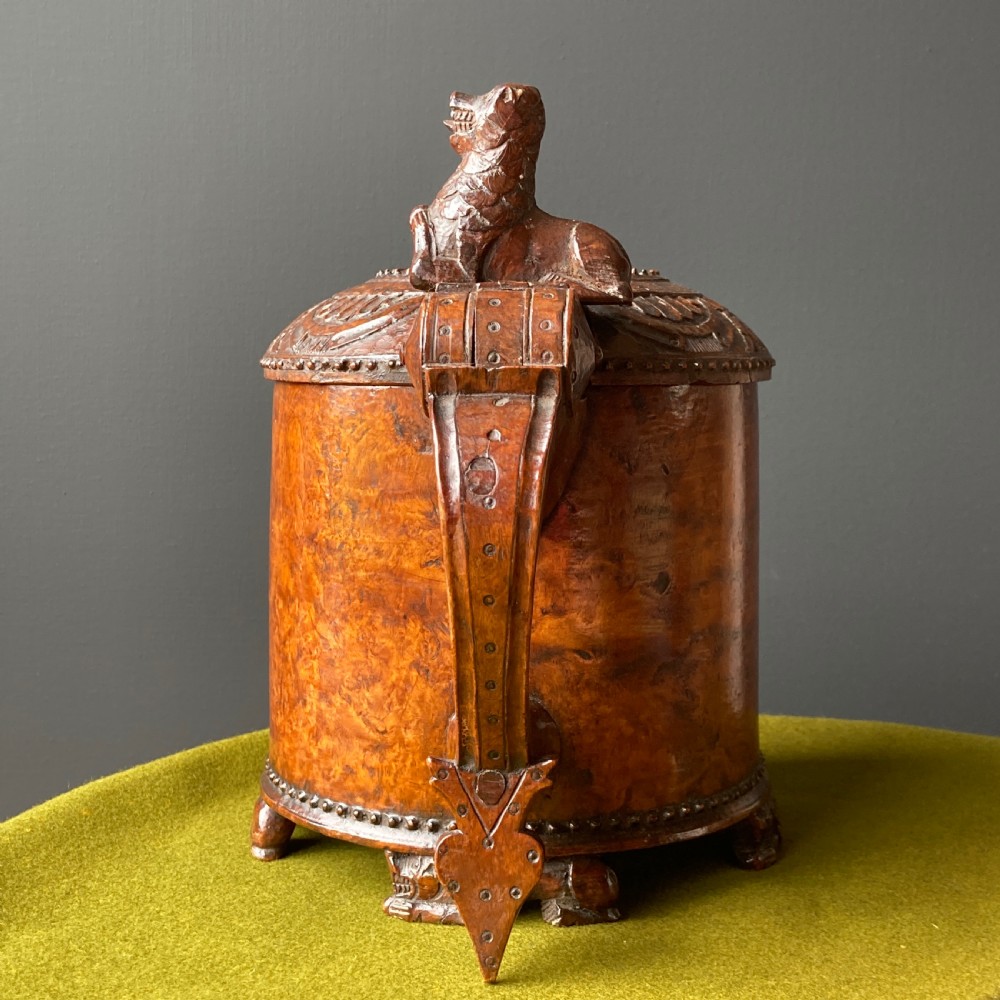 An 18th-century Norwegian carved wooden peg tankard featuring a lion thumbpiece, domed relief-carved lid, and carved lion feet in a warm brown finish. View III