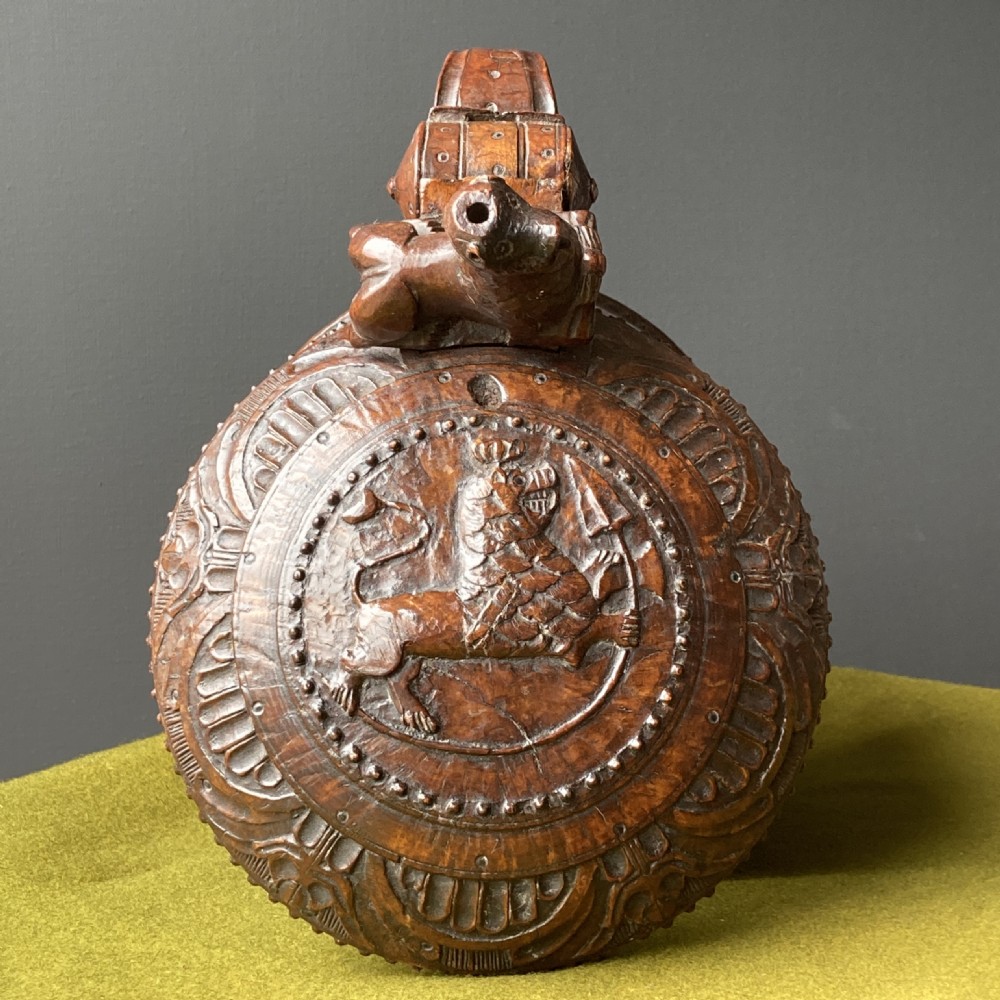 An 18th-century Norwegian carved wooden peg tankard featuring a lion thumbpiece, domed relief-carved lid, and carved lion feet in a warm brown finish. View VIII