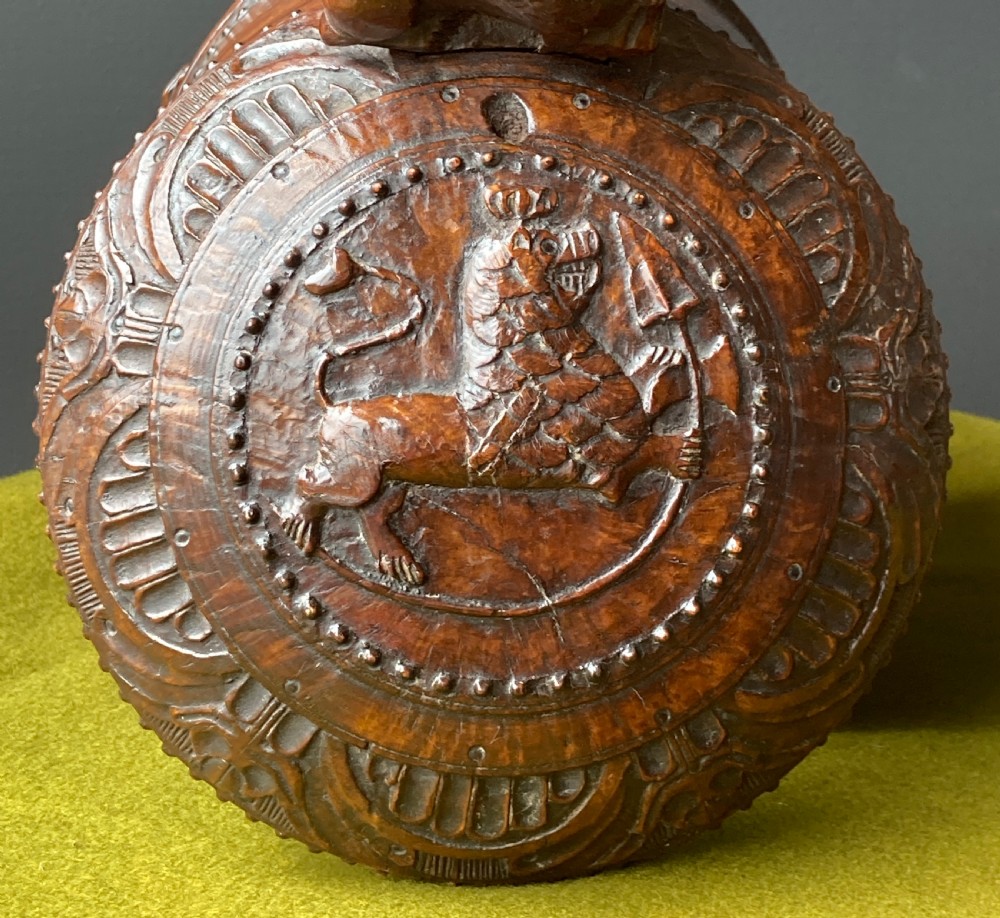An 18th-century Norwegian carved wooden peg tankard featuring a lion thumbpiece, domed relief-carved lid, and carved lion feet in a warm brown finish. View XII