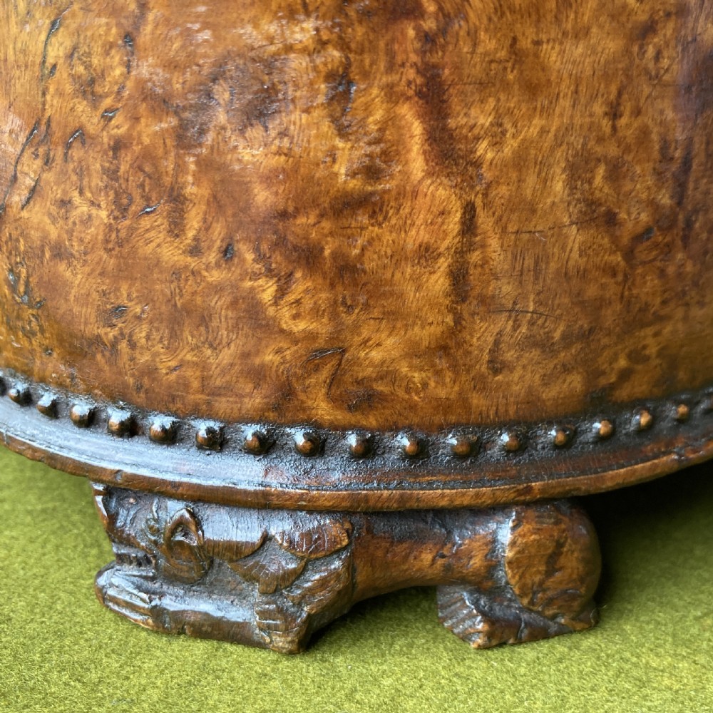An 18th-century Norwegian carved wooden peg tankard featuring a lion thumbpiece, domed relief-carved lid, and carved lion feet in a warm brown finish. View XIV