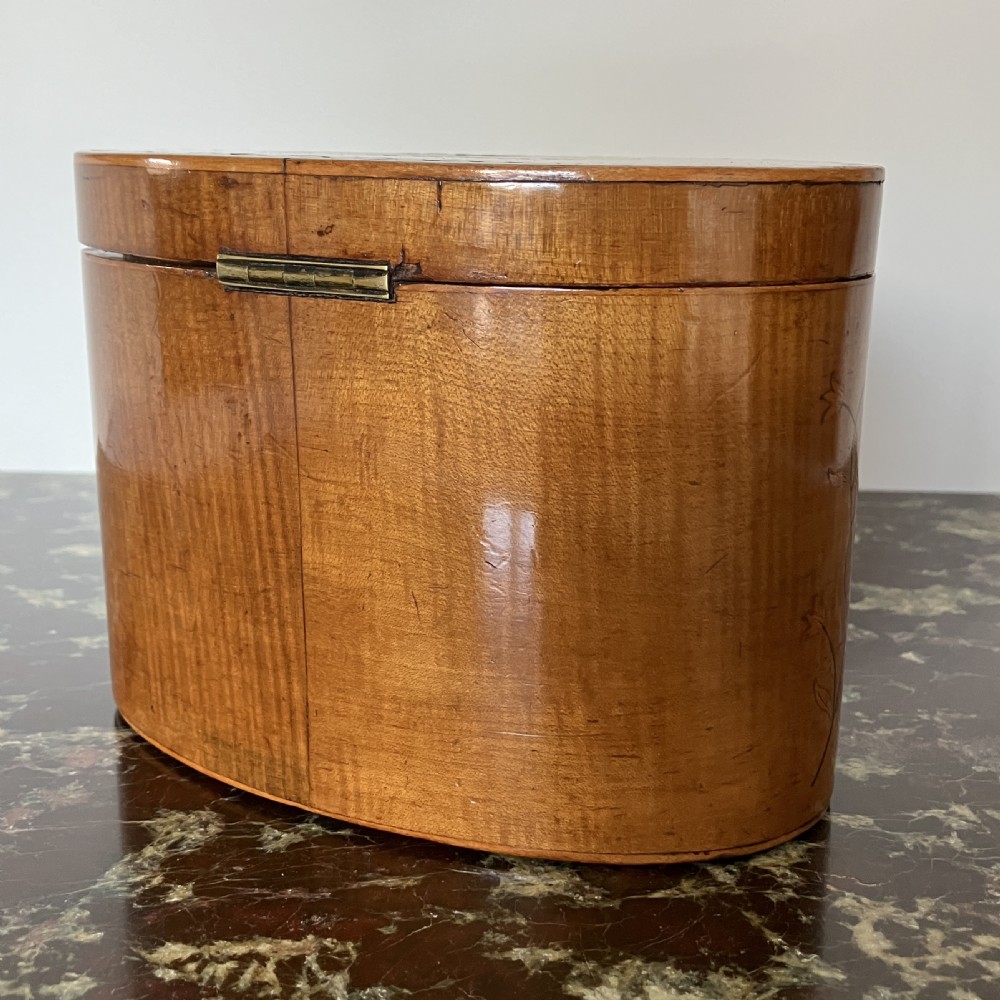 An oval George III satinwood tea caddy featuring floral marquetry inlay on the front, a top medallion motif, and an escutcheon with a key. View VI