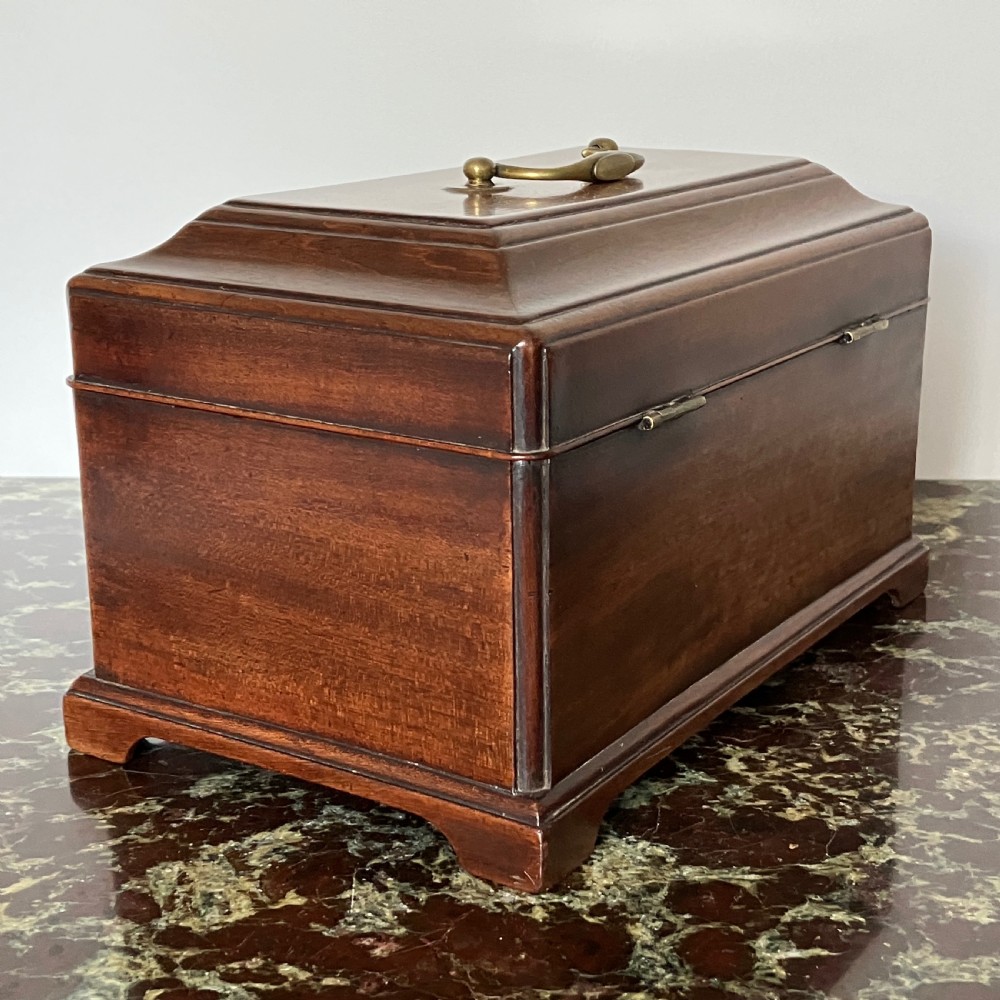 A rectangular Georgian mahogany tea caddy with a stepped lid, top brass handle, and decorative brass escutcheon. View VIII