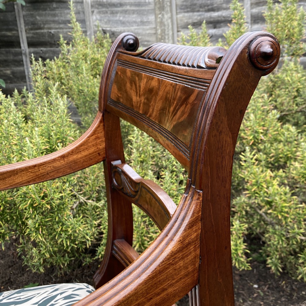 A George III mahogany desk armchair featuring reeded arms, a tablet top rail with flame mahogany veneer, and a patterned upholstered seat. View V