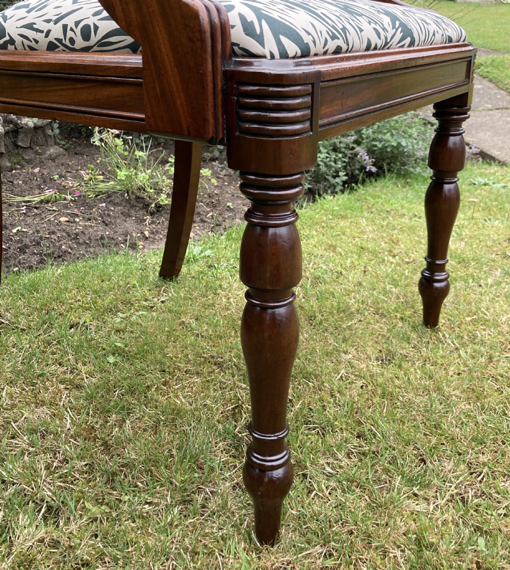 A George III mahogany desk armchair featuring reeded arms, a tablet top rail with flame mahogany veneer, and a patterned upholstered seat. View IX