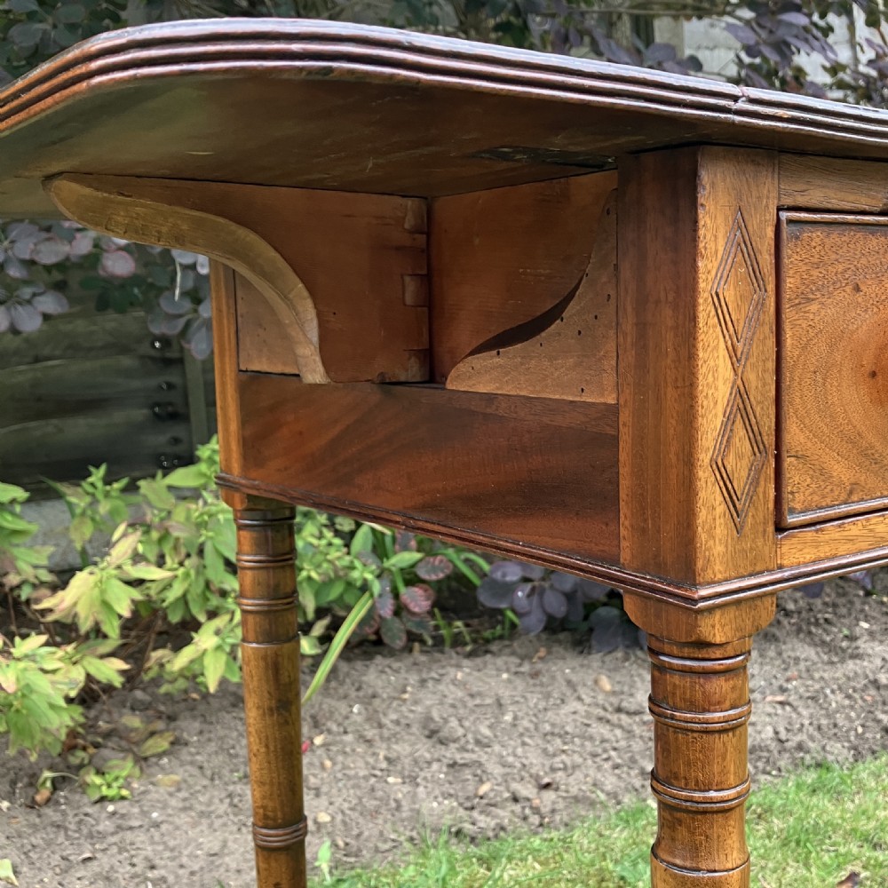 A late Georgian mahogany work table featuring twin drop leaves, a single drawer with wooden knobs, inlaid diamond details, and turned legs on brass castors. View VI