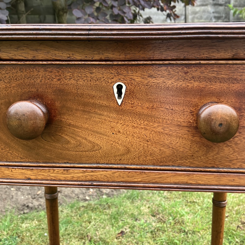 A late Georgian mahogany work table featuring twin drop leaves, a single drawer with wooden knobs, inlaid diamond details, and turned legs on brass castors. View VIII