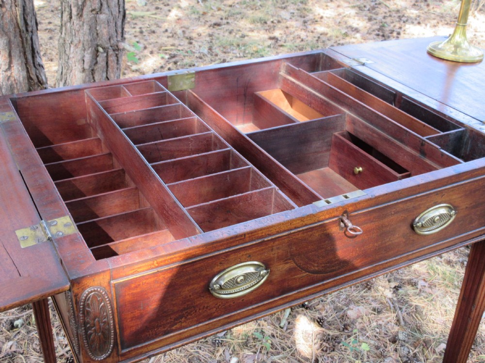 A George III mahogany estate rent table featuring an adjustable leather writing slope, document compartments, side flap extensions, and fluted legs. View II
