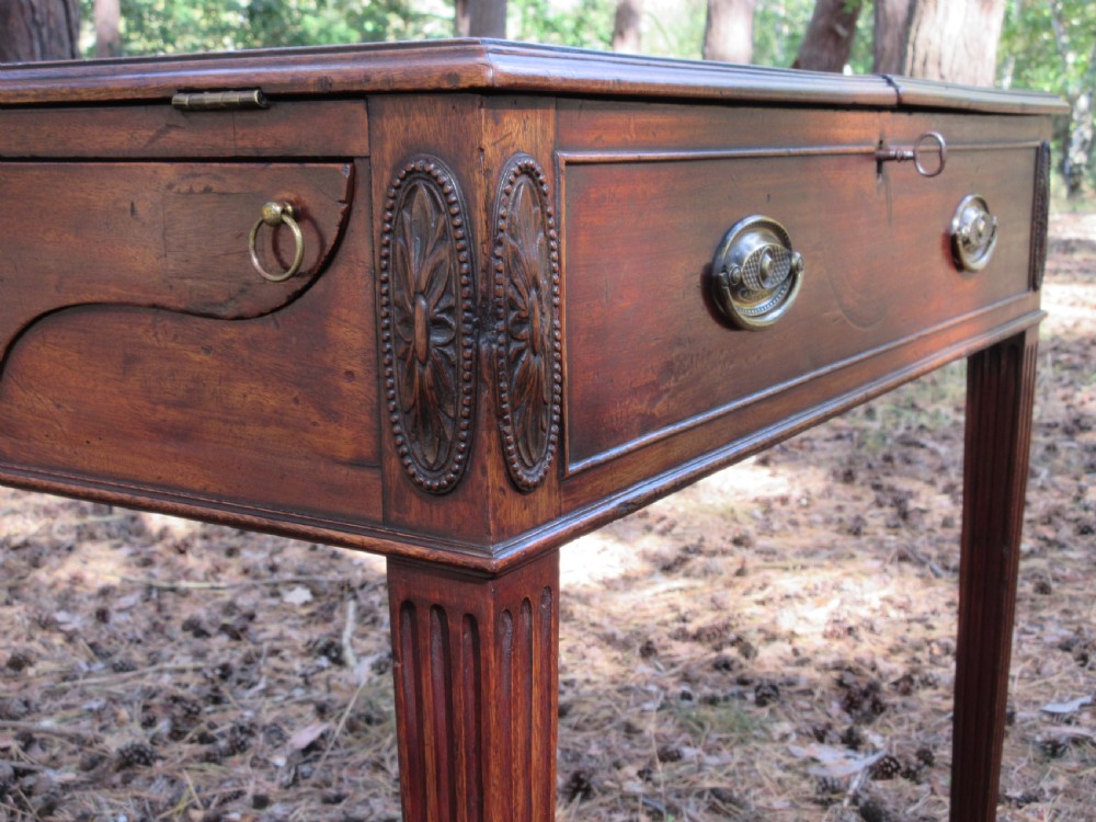 A George III mahogany estate rent table featuring an adjustable leather writing slope, document compartments, side flap extensions, and fluted legs. View VII