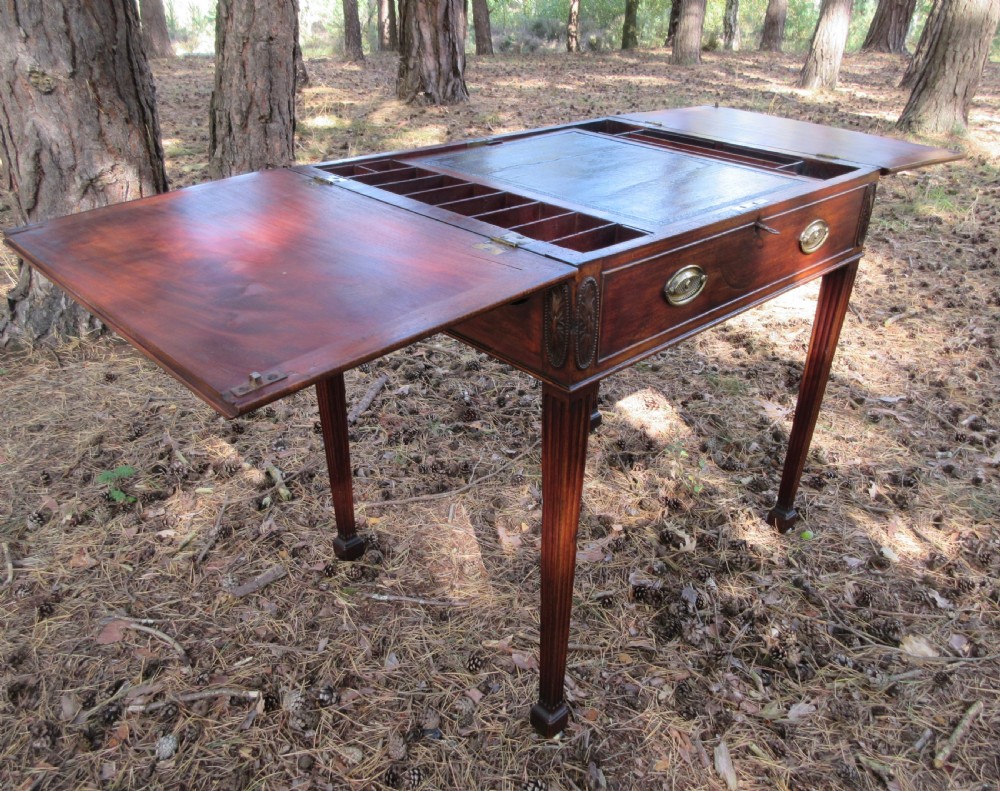 A George III mahogany estate rent table featuring an adjustable leather writing slope, document compartments, side flap extensions, and fluted legs. View IX