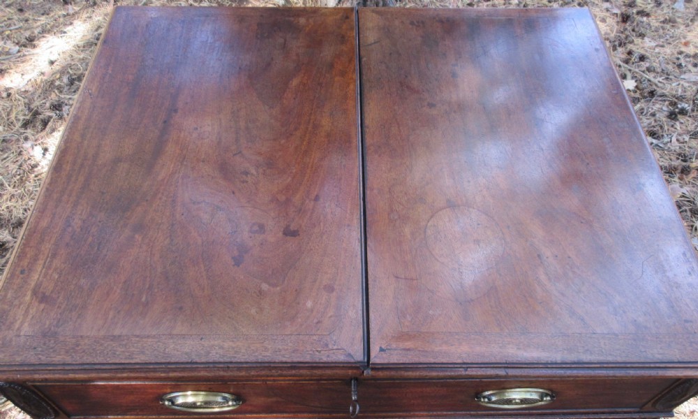 A George III mahogany estate rent table featuring an adjustable leather writing slope, document compartments, side flap extensions, and fluted legs. View X