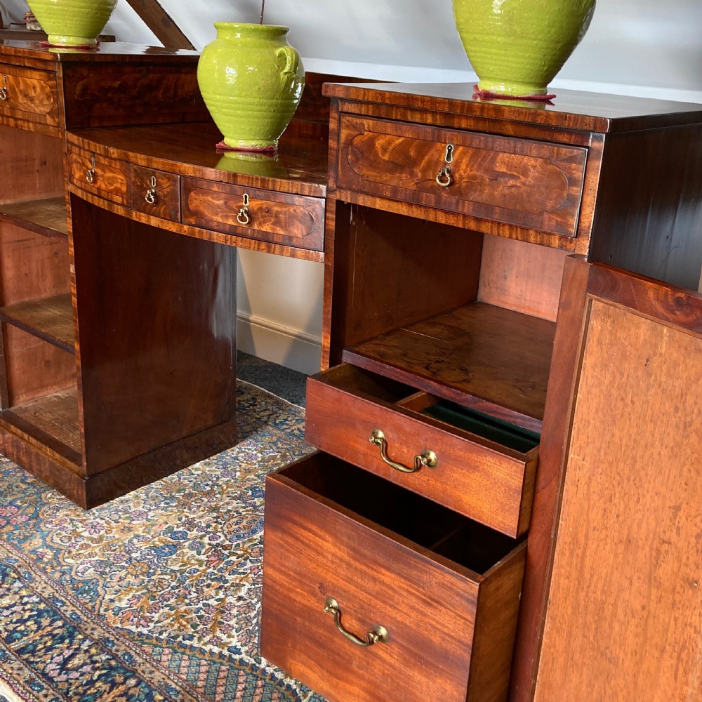 A late Georgian mahogany pedestal sideboard featuring two outer pedestals with floral fabric panels, central drawers, and warm flame mahogany wood grain. View V