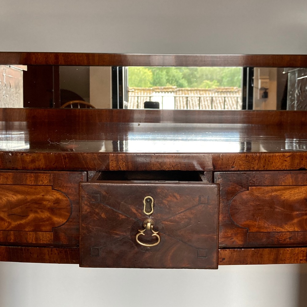 A late Georgian mahogany pedestal sideboard featuring two outer pedestals with floral fabric panels, central drawers, and warm flame mahogany wood grain. View XIV