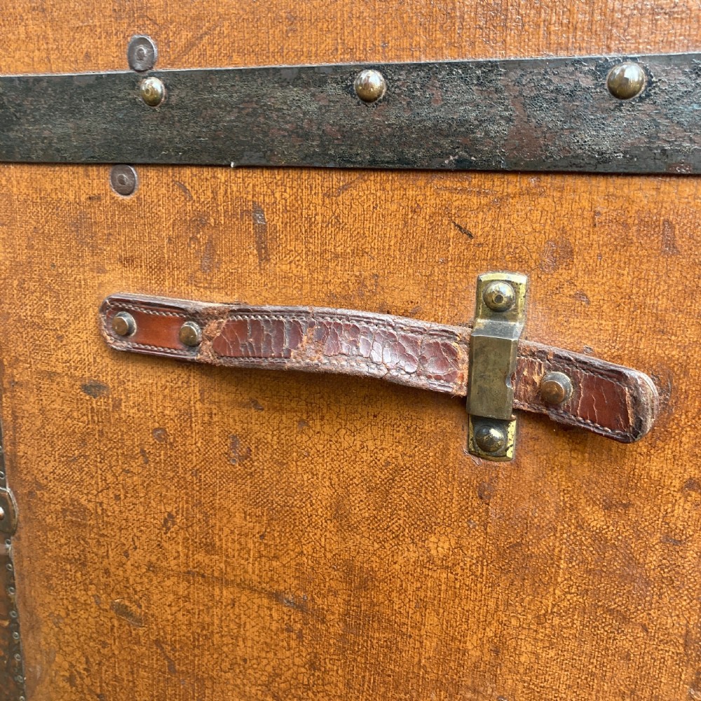 A late nineteenth-century domed steamer trunk with brown fabric covering, dark wooden banding, metal studs, and central brass lock hardware. View IV
