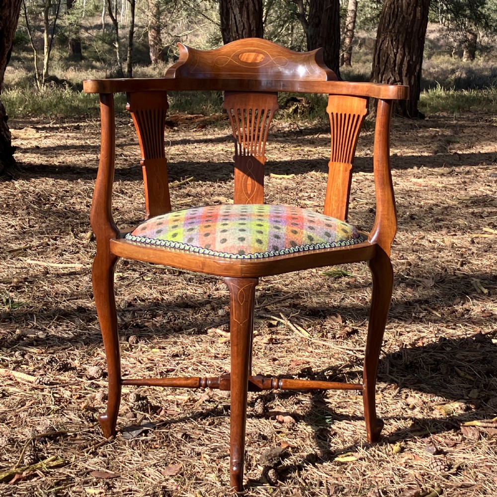A pair of Edwardian mahogany corner chairs featuring curved top rails with marquetry inlay, vertical splats, upholstered patterned seats, and slender legs joined by stretchers. View II