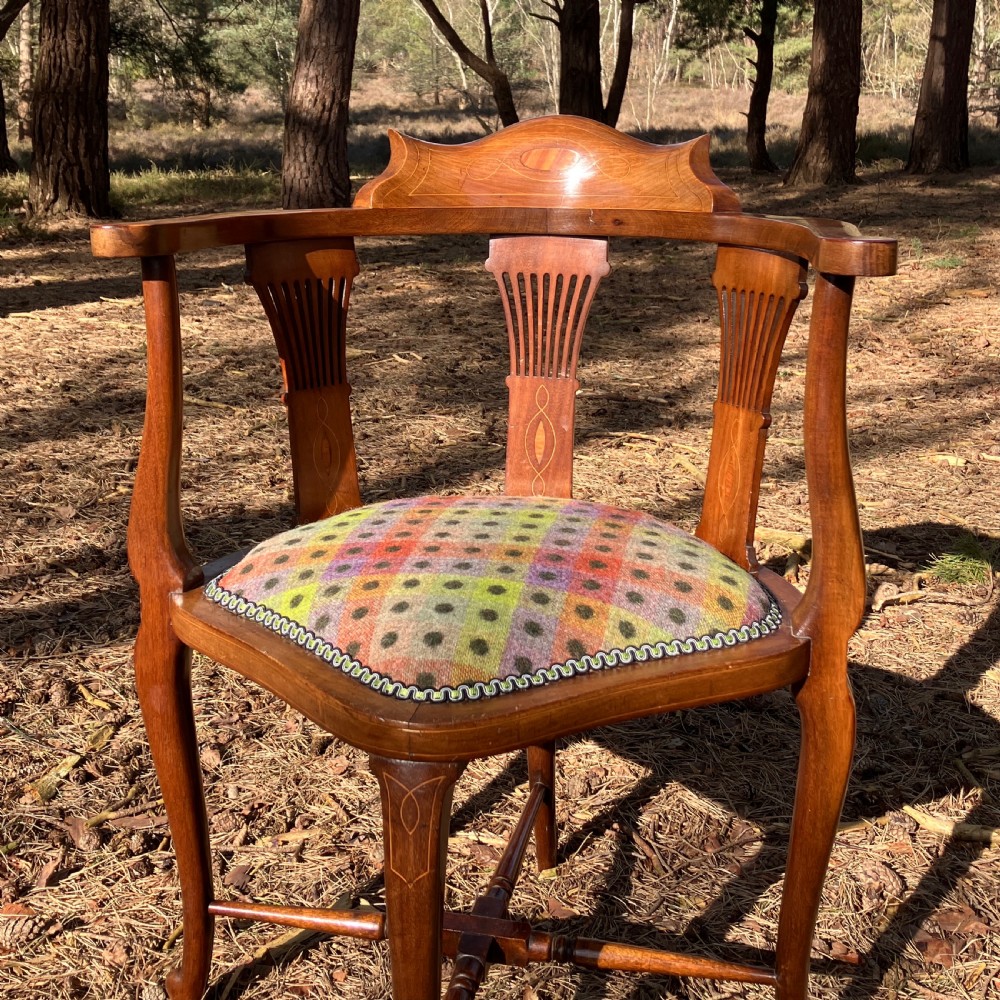 A pair of Edwardian mahogany corner chairs featuring curved top rails with marquetry inlay, vertical splats, upholstered patterned seats, and slender legs joined by stretchers. View IX