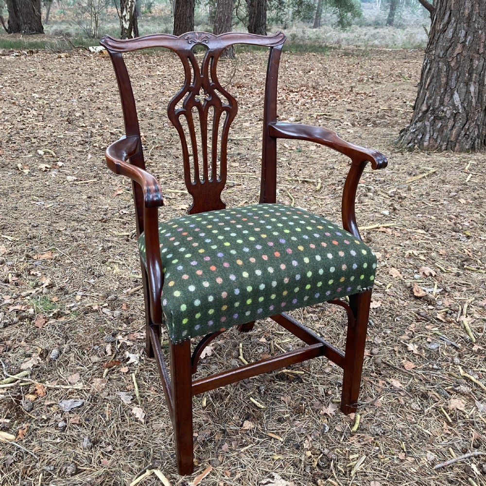 A pair of 1830s mahogany open armchairs featuring carved top rails, pierced splats, swept arms, and seats upholstered in a green patterned fabric. View II