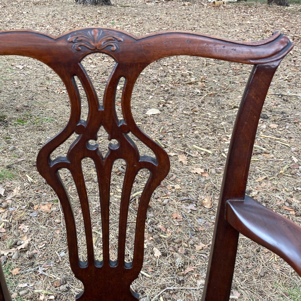 A pair of 1830s mahogany open armchairs featuring carved top rails, pierced splats, swept arms, and seats upholstered in a green patterned fabric. View VII