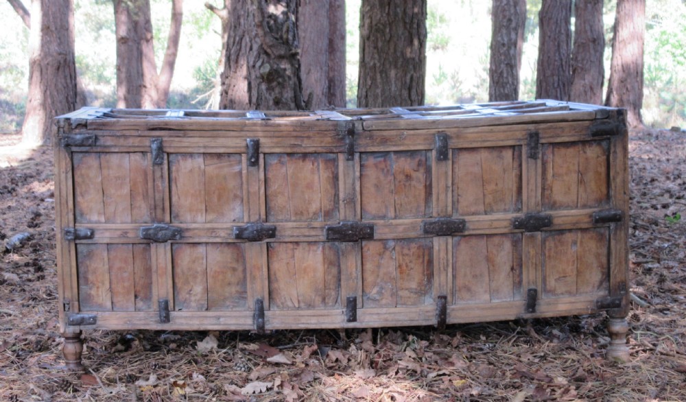 A large 19th-century Indian timber marriage chest featuring panelled sides, iron strapping, and turned feet. View III