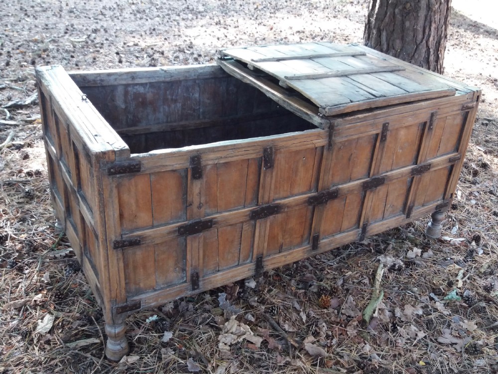 A large 19th-century Indian timber marriage chest featuring panelled sides, iron strapping, and turned feet. View IV