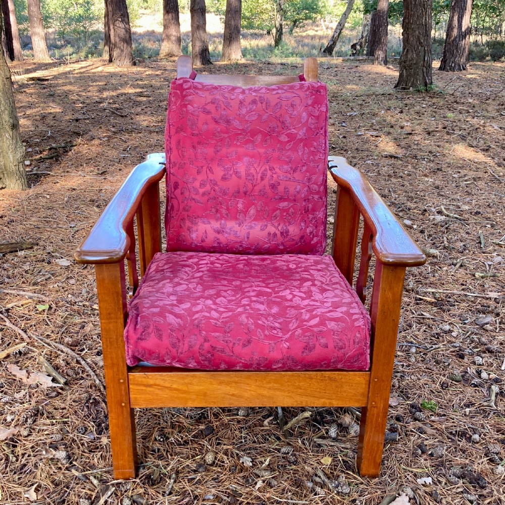 An Edwardian teak reclining armchair featuring slatted side panels, wide flat armrests, and pink floral upholstered cushions. View II