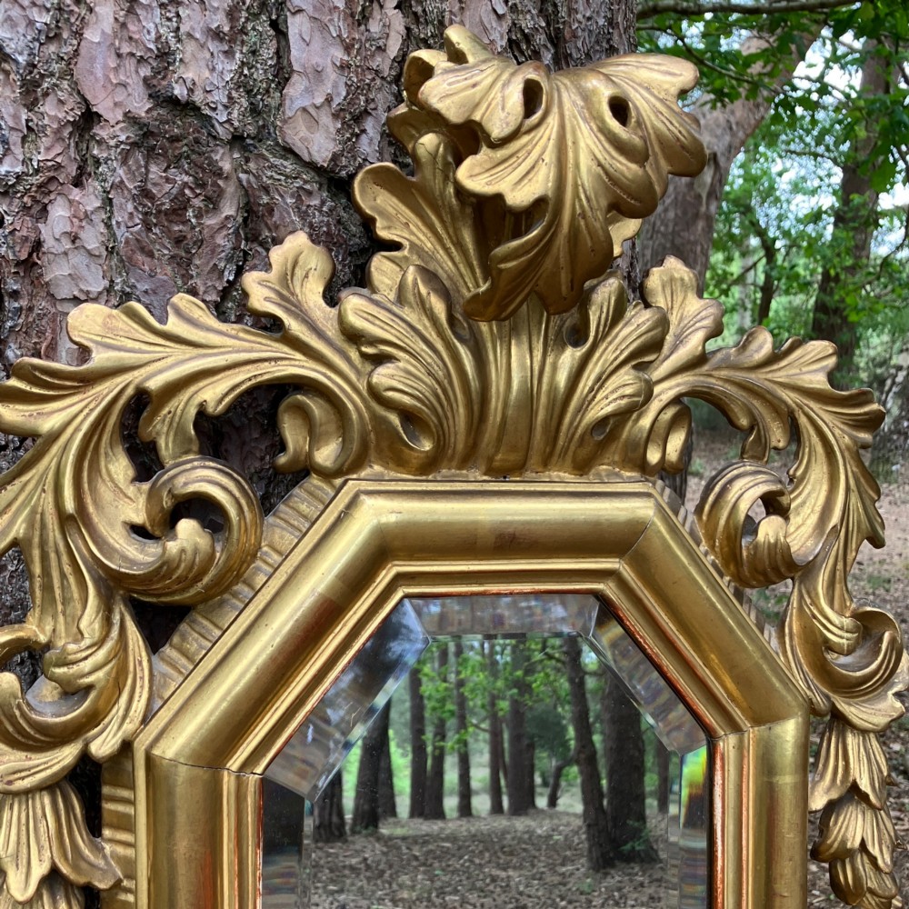 An octagonal 19th-century French giltwood girandole wall mirror featuring carved acanthus leaf motifs and an integrated central candle sconce holding a single candle. View V