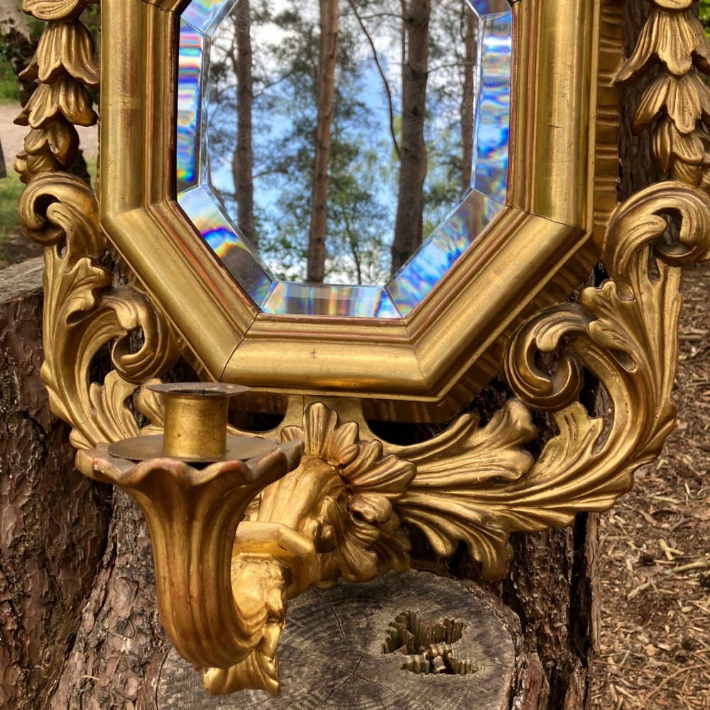 An octagonal 19th-century French giltwood girandole wall mirror featuring carved acanthus leaf motifs and an integrated central candle sconce holding a single candle. View VIII